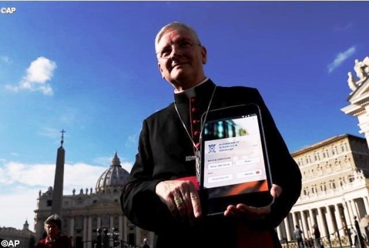 archbishop-leo-cushley-holds-up-a-poster-showing-how-a-new-app-to-find-the-nearest-church-for-holy-mass-or-confession-is-going-to-look-like-ap