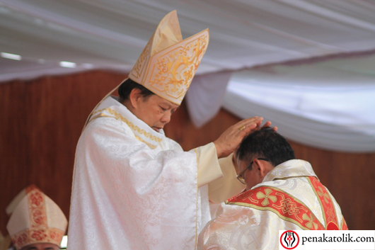 Uskup Surabaya Mgr Vincentius Sutikno Wisaksono memberi penumpangan tangan. Foto PEN@ Katolik