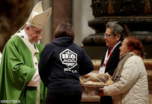 Paus Fransiskus menerima persembahan roti saat dia memimpin Misa khusus untuk merayakan Hari Orang Miskin se-Dunia yang pertama di Basilika Santo Petrus di Vatikan, 19 November 2017 - REUTERS
