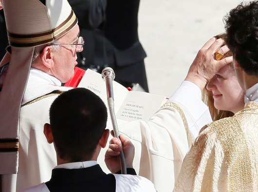 Paus Fransiskus ketika mengurapi seorang perempuan dengan minyak krisma/Foto CNS oleh Paul Haring