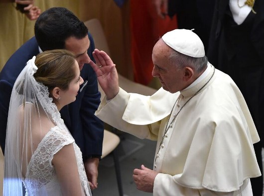 Paus Fransiskus memberkati pasangan nikah. Foto: Alberto Pizzoli/Getty