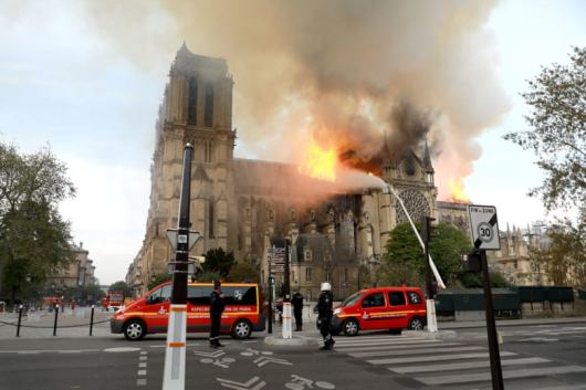 Petugas pemadam kebakaran memadamkan api di katedral dengan air dari selang. Foto Pierre Suu/Getty Images 
