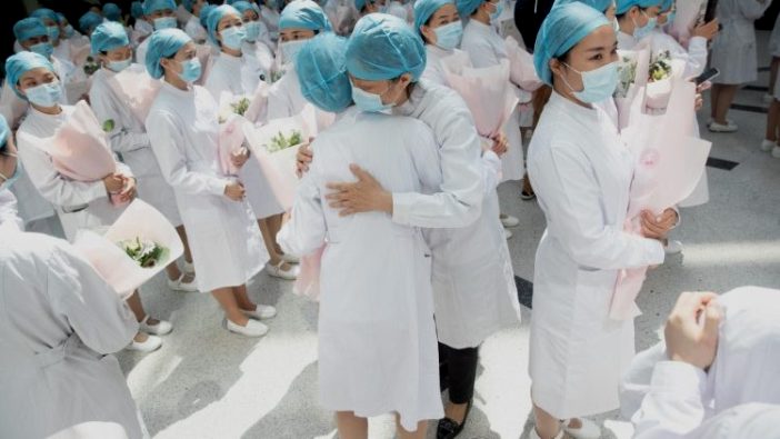 Para perawat Cina berpelukan saat  perayaan Hari Perawat Internasional, Wuhan, Cina (ANSA)