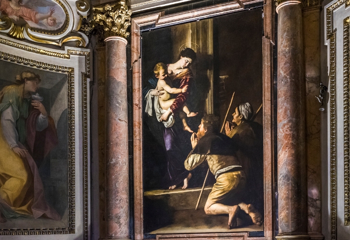 “Madonna of the Pilgrims,” satu dari mahakarya Basilika Sangto Agustinus. Lukisan Caravaggio itu melangga kesopanan saat itu karena itu menggambarkan para peziarah malang yang berlutut di hadapan Bunda Maria dengan kaki yang telanjang dan kotor. © Andrea Colarieti | Shutterstock 