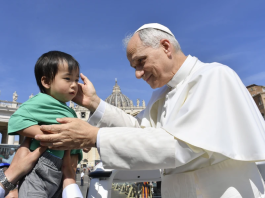 Paus Leo XIV memberkati seorang anak di Vatikan. NCR