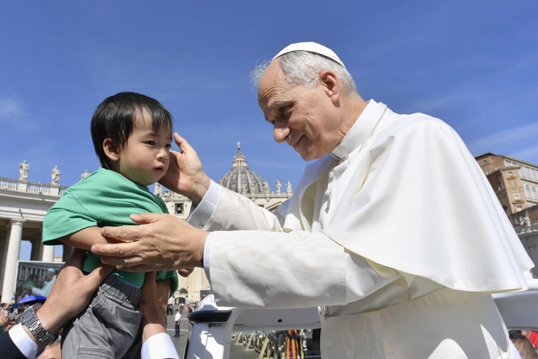 Paus Leo XIV memberkati seorang anak di Vatikan. NCR