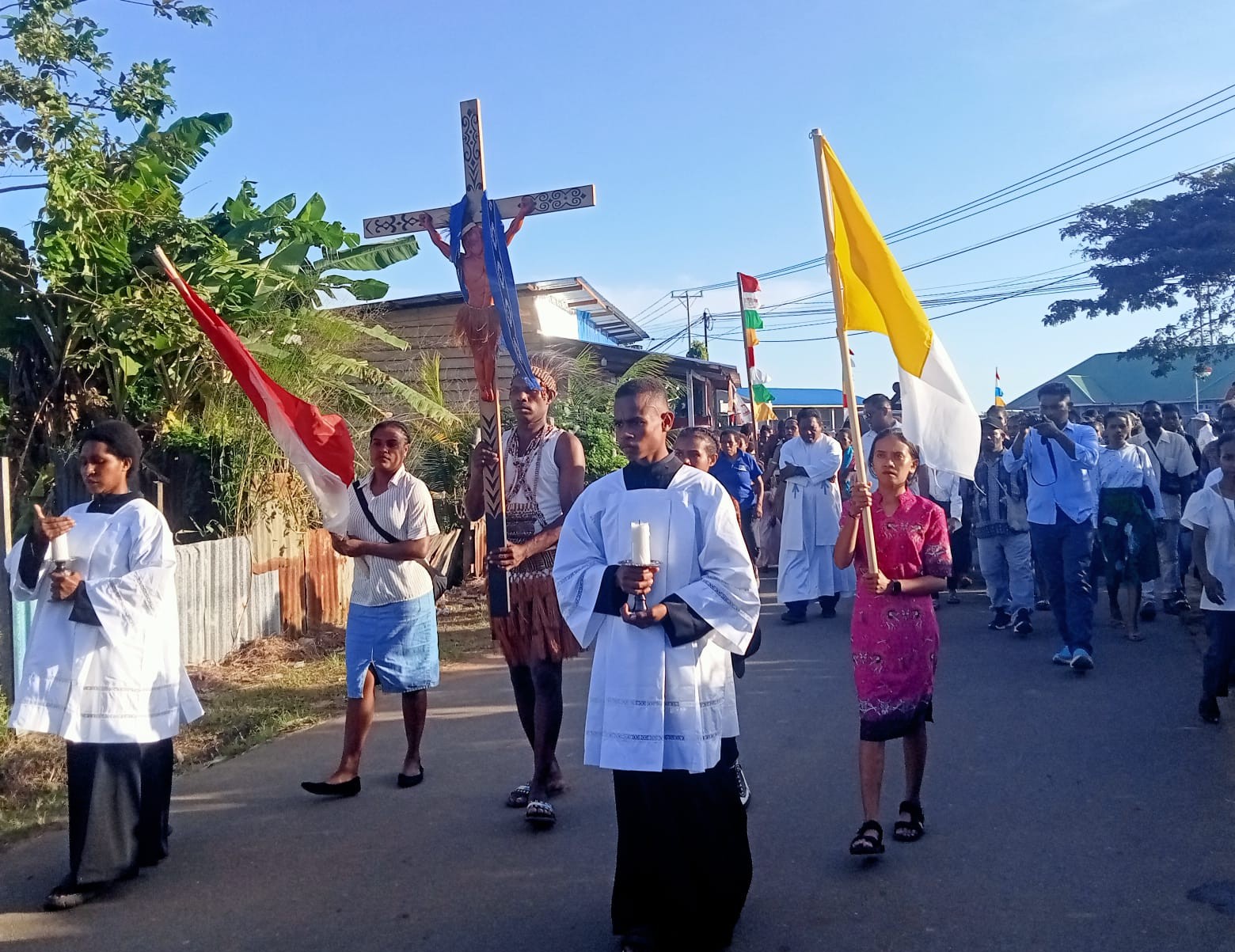 Salib PYD sedang diarak menuju Gereja Stasi Bunda Hati Kudus Yesus Jati-jati diiringi tarian Suku Mappi menuju Gereja. Foto. Agapitus Batbual