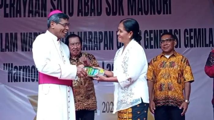 Maria Magdalena Wea, Kepala SDK Maunori menyerahkan buku kenangan satu abad SDK Maunori kepada Uskup Agung Ende, Mgr. Paul Budi Kleden, Kamis 31 juli 2025