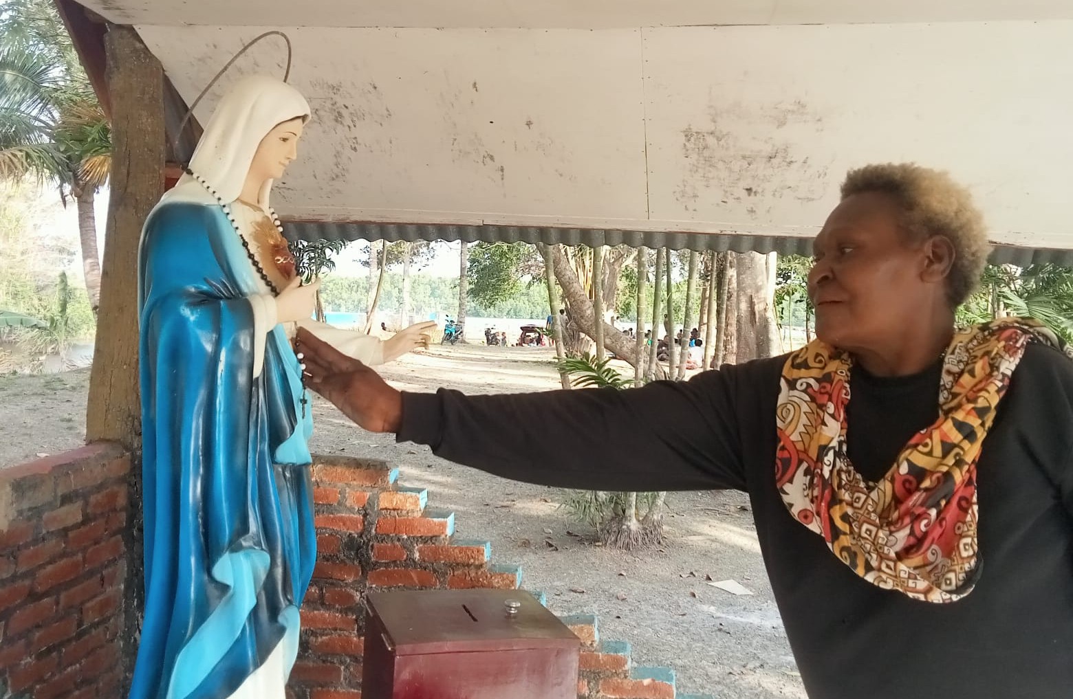 Mama Adolfia Kaize sedang mengusap wajah Arca Bunda Maria di yonggo usai kerja bakti membersihkan areal yonggo di Stasi Sirapuh. Foto. Agapitus.Batbual